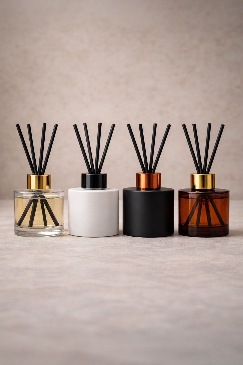 White label reed diffuser collection in clear, white, black and amber bottles with reeds